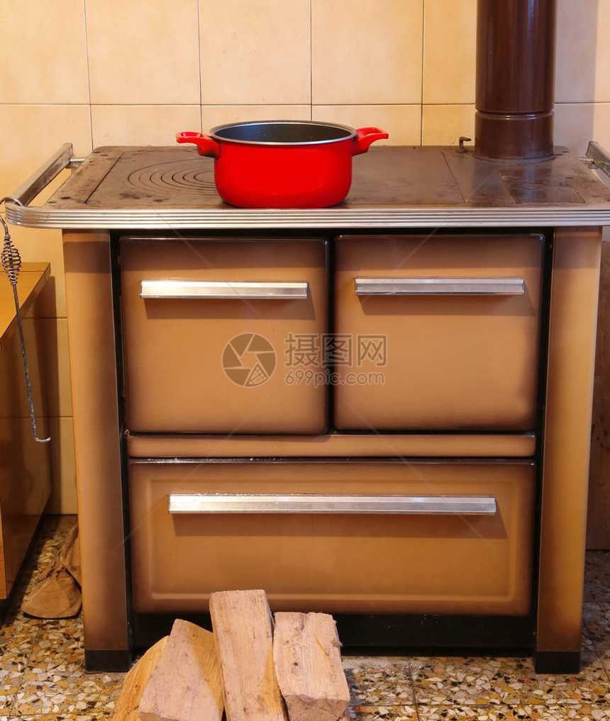小房子厨房里的柴火炉和一个红锅图片