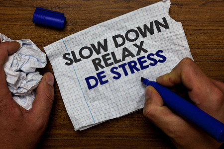 休息的商业概念降低压力水平休息冷静手握纸吊和蓝色标记木底座图片