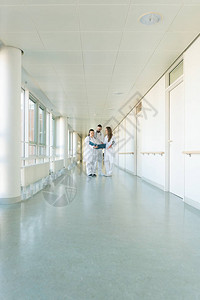 医院走廊上的三位医生开会讨论一些病例图片