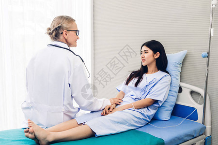 女医生咨询和牵着女病人的亲手看病背景图片