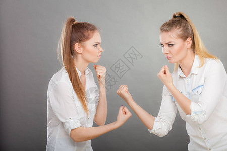 友谊困难有争论的两个少妇愤怒的女孩互相尖图片