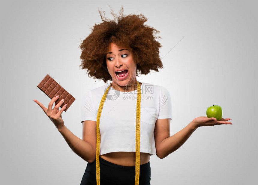 年轻身体健康的女选择吃健康饮食或巧克力图片