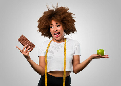 年轻身体健康的女选择吃健康饮食或巧克力图片
