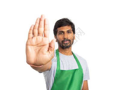 印度商店主或雇员持棕榈手势停止手势图片
