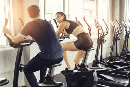 健身女人在健身房锻炼自行车健身和健康的生活方式h机器有氧图片