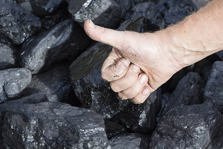矿工在煤炭的背景上竖起大拇指展示煤炭图片
