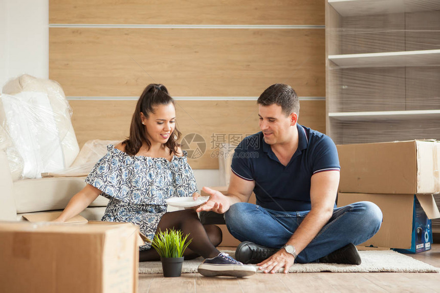 快乐的年轻夫妇在他们的新公寓里拆开行李箱图片