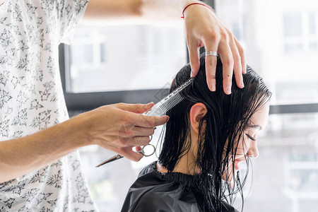专业美发师造型师在专业美发沙龙梳理女客户的头发美图片