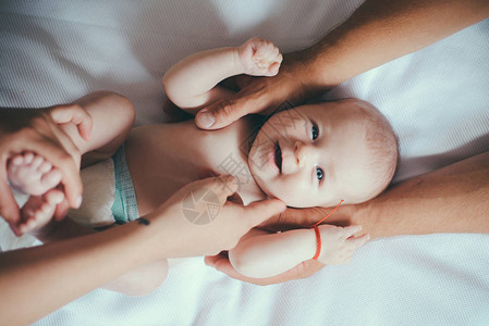 非常轻柔地给宝按摩刚出生的女婴或男婴新生儿护理与婴儿的家庭关系家图片