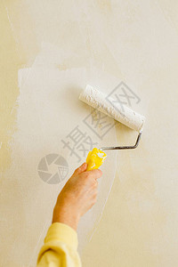 用油漆滚筒刷墙的画家手臂的特写复制空间图片