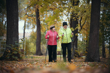 老年妇女在秋天公园中走动当时正在图片