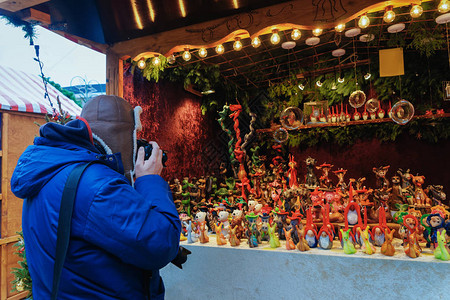 男子在德国柏林冬季威廉皇帝纪念教堂圣诞市场的摊位上拍照AdventFair装饰和集市上背景图片