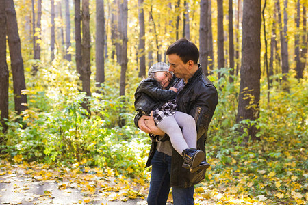 快乐的家父和儿女在秋叶中散步图片