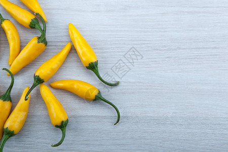 灰色背景顶视图中黄色鲜辣椒的果实背景图片