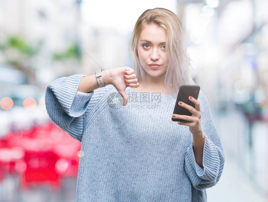 年轻的金发女子在孤立的背景下用智能手机发短信图片