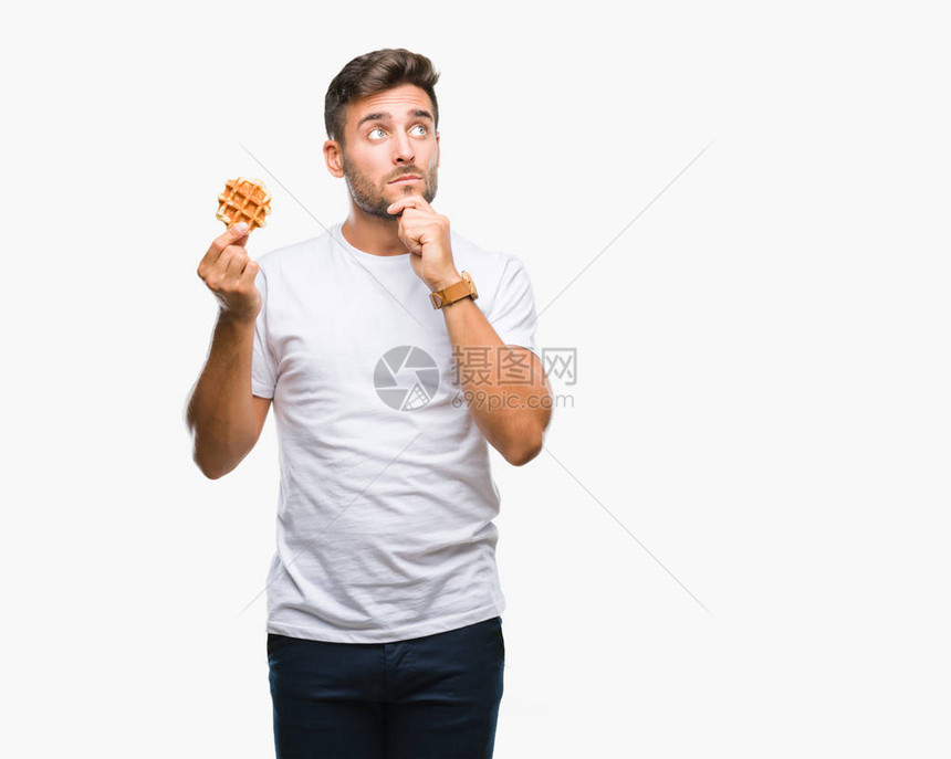 年轻帅哥在与世隔绝的背景下吃着甜华夫饼图片