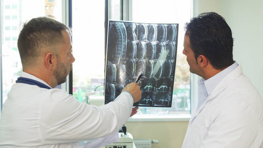 医生们站在窗前他们看着X射线并研究它这是他们病人的光片他们图片