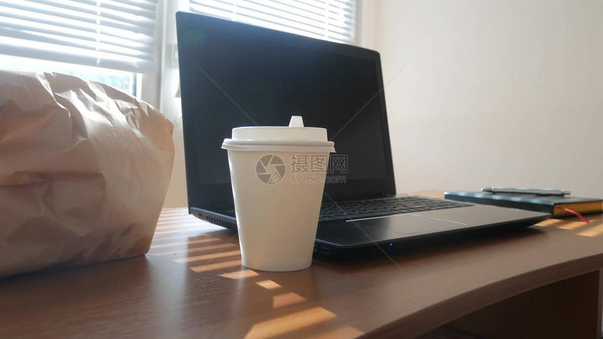 用来装咖啡和快餐打开笔记本电脑在办公室吃早餐图片
