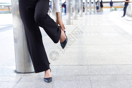 妇女在办公室工作时因鞋子受伤痛背景图片