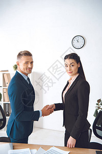 商业同事在办公室工作单位握手的一图片