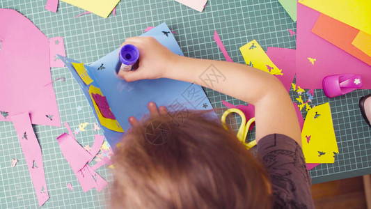 顶视图剪贴簿胶合彩色纸的小女孩的手儿童创图片