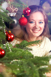 在家客厅装饰圣诞树的快乐女人图片