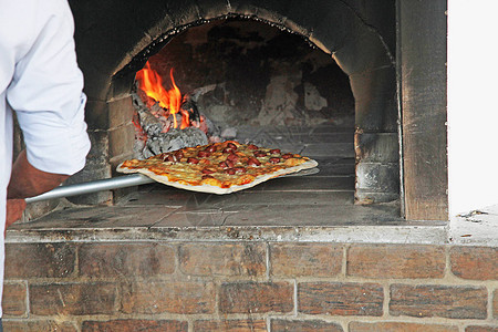 从餐厅的木柴比萨烤箱里出来的比萨图片