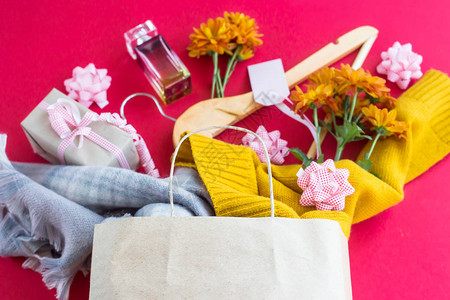 妇女购买的纸工艺包衣服礼品香水鲜花和衣架图片