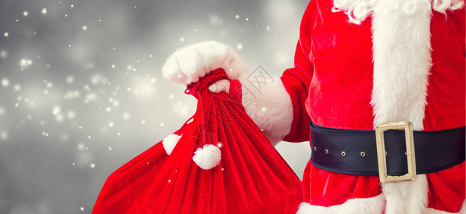 圣诞老人拿着红色麻袋在闪亮图片