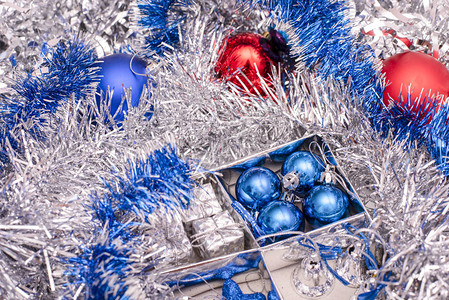 由蓝星蓝圣诞球银铃和银罐之间盒装的礼品盒组成的圣诞玩具图片
