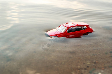 红色玩具车被淹没在水下顶绿水和沙子在图片