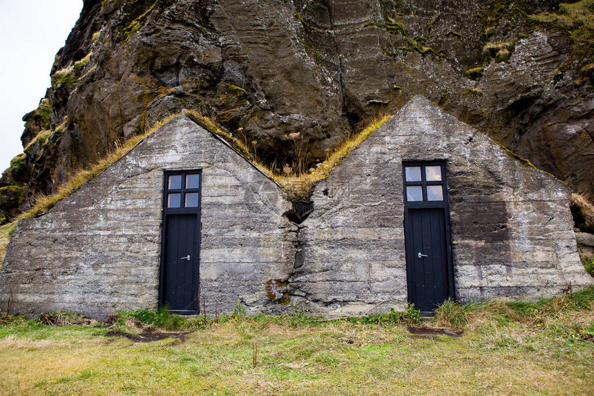 用草盖的典型的冰岛房子背景中覆盖着草和悬崖的冰岛草皮房子美丽的斯堪图片