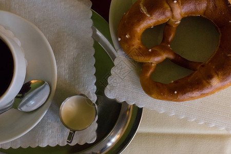 德国椒盐脆饼配奶油和一杯黑咖啡图片