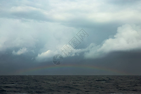 风雨如磐的海面上的彩虹图片