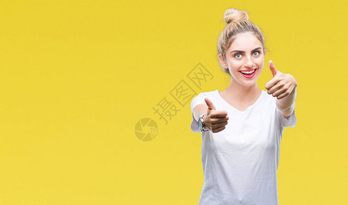 年轻漂亮的金发女郎穿着白色T恤在孤立的背景下批准用手做积极的手势图片