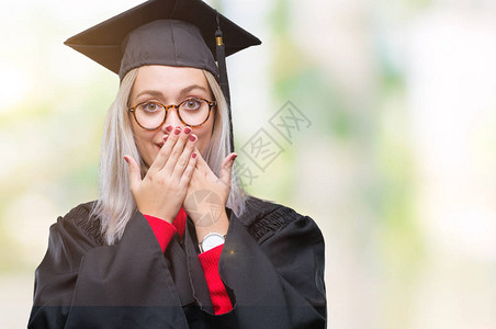身穿毕业制服的金发年轻女郎在孤立的背景之下被吓得满嘴胡言乱语地用图片