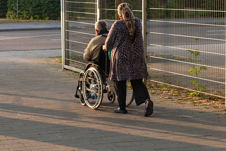 高龄夫妇和轮椅在南德部露天公园的户外公园春季历史城市阳图片