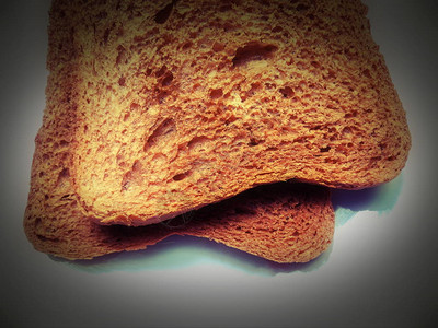 一片面包刚从烤面包机里取出来的麦芽面包吐司很烫白色背景特写宏图片