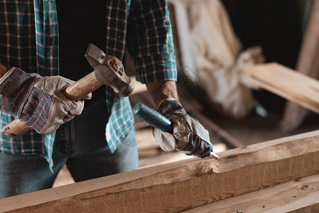 木工在木工车间工作木匠用锤子和凿子处理木头家庭图片