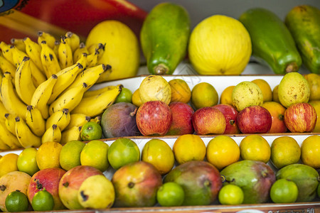 超市货架上的新鲜健康水果从香蕉苹果瓜木瓜橙番石榴柠檬图片
