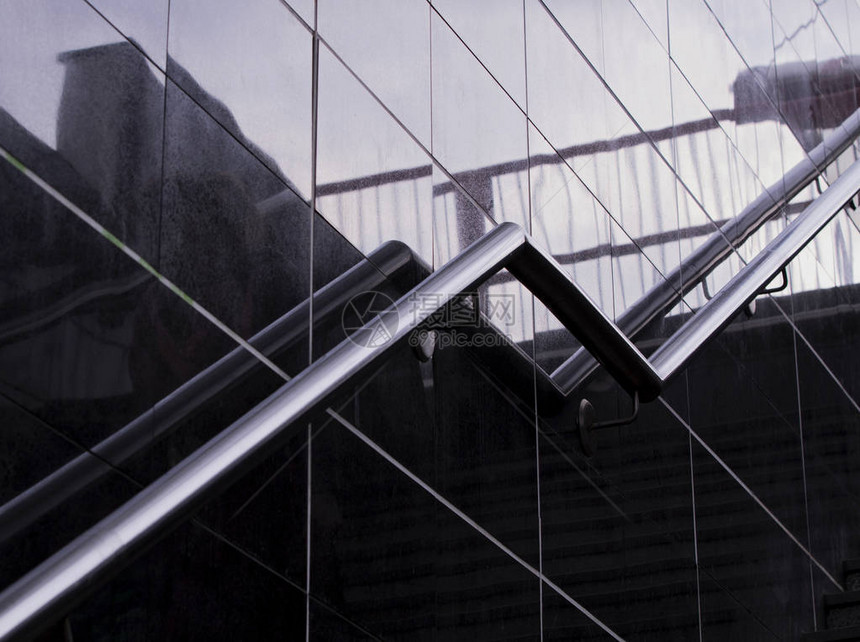 楼梯不锈钢扶手新现代地下通道中带不锈钢栏杆的现代楼梯玻璃墙上的反射和阴图片