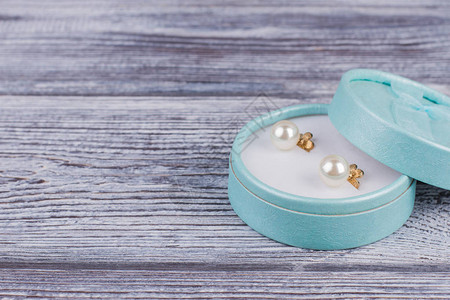 一对金珍珠耳环放在礼物盒里花朵时尚珍珠耳环美图片