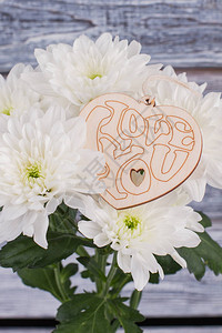 菊花和心形的木制标签情人节假期背景与白色的花朵和心形的木制装饰品爱情图片