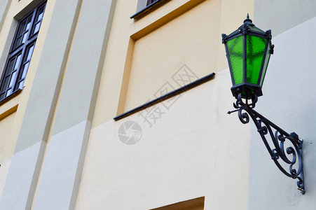 大金属绿色铁高街灯在一座旧石块建筑的图片