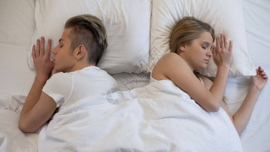男人和女人静悄地睡着躺回床图片
