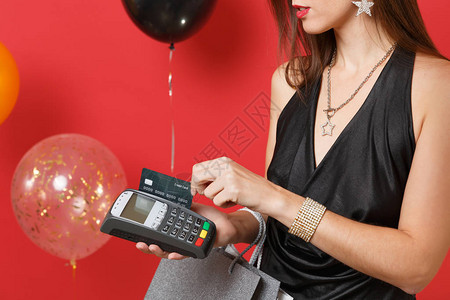 女孩的特写手持无线现代银行支付终端处理信用卡支付图片