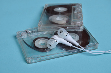 绿色蓝底的塑料透明录音带和白色真空耳机80年代图片