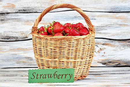 木本底新鲜采摘的草莓Wicker篮子里装满了多汁的草莓图片