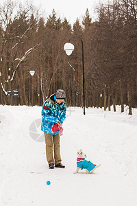 宠物主人和冬季概念中年妇女在雪地公园玩图片