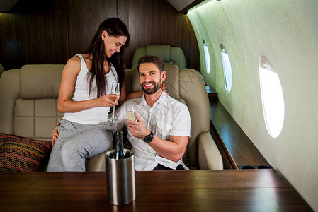 乘坐豪华私人飞机旅行的幸福夫妇图片